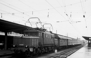 Фото на котором наш прототип ещё со старой нумерацией, но с некоторыми внешними изменениями, присущими уже третьей эпохе. Помимо перекраски в зелёный, это ещё и третий фонарь, место которого теперь на капоте, а не под крышей, как это было на локомотивах второй эпохи. Причиной такого переноса стали жалобы машинистов на нежелательные переотражения света. Такую процедуру прошли все Е93 до 1962 года, что говорит о том, что фото произведено несколько ранее